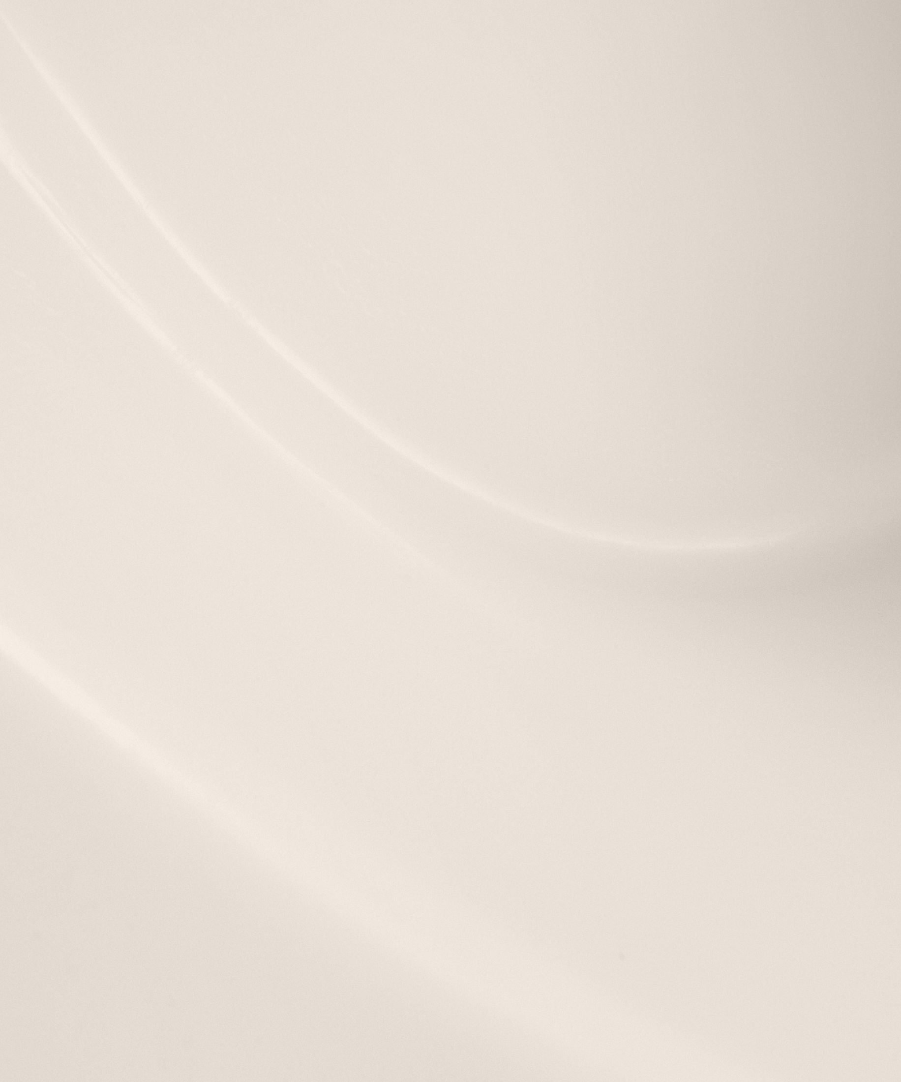 Curved, smooth surface in soft beige tones.