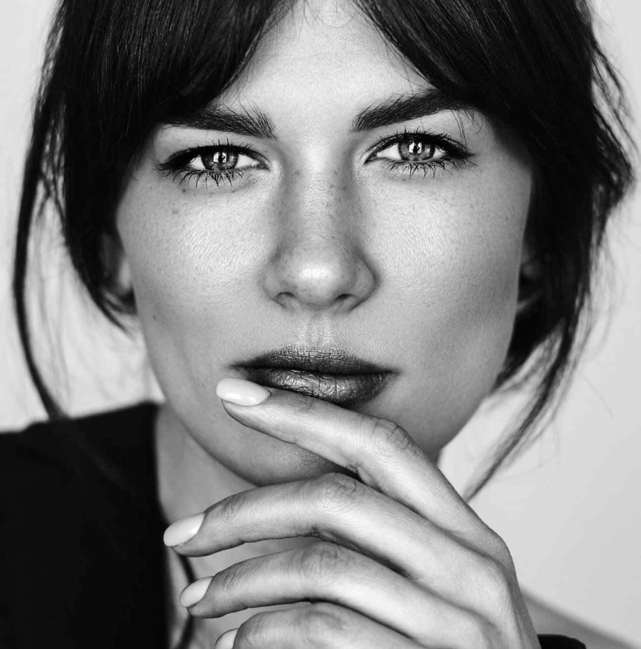 Black and white close-up of thoughtful woman.