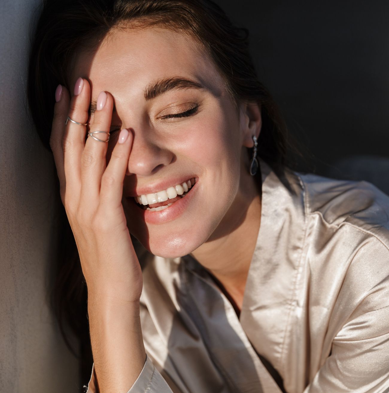 Smiling woman with hand on her face.
