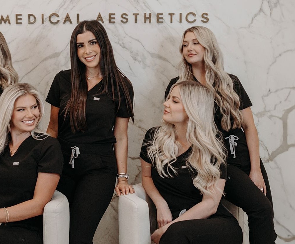 Aesthetic professionals posing in clinic setting.